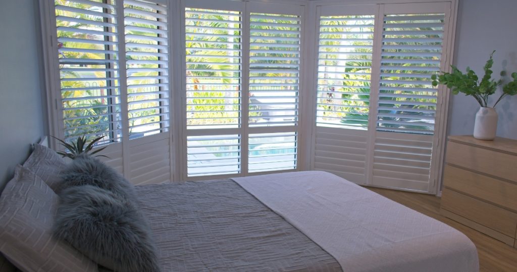 White customised plantation shutter in bedroom